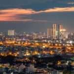 Vibrant Ho Chi Minh City skyline illuminated against a dusk sky, featuring modern skyscrapers.